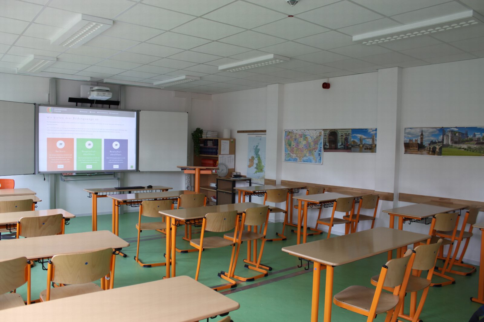 Klassenzimmer der Abendoberschule Chemnitz mit Schulbänken und Beamer, auf dem die neue Website zu sehen ist